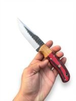 Red and Black Wood Handle Fixed Blade Hunting Knife with polished and dark two-tone blade beside a brown basketweave-style sheath