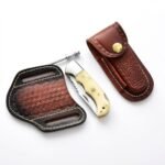 Cream Handle Fixed Blade Knife with polished pointed blade, silver bolster, decorative handle pins and lanyard hole displayed in an open hand