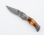 Damascus Folding Pocket Knife with silver-gray patterned blade, amber-brown handle, decorative metal bolsters and thumb stud
