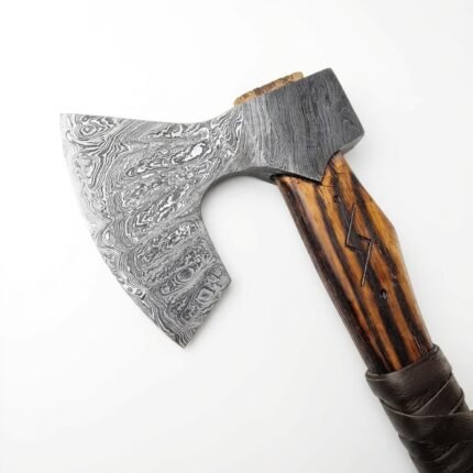 Damascus Pattern Viking Bearded Axe with broad curved silver-gray patterned head, brown wood-grain shaft, angular decorative marking and dark wrapped handle