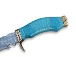 Turquoise Handle Damascus Pattern Knife with curved silver-gray blade, decorative gold-tone guard, blue patterned grip and brown multi-strap sheath.