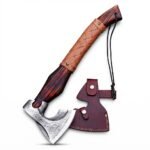 Engraved Viking axe with silver-gray bearded head, Nordic knotwork patterns, long reddish-brown wood-look handle and tan basketweave-patterned wrap, held by a black-gloved hand.