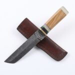 Damascus Utility Knife featuring a silver-gray patterned blade, curved pointed tip, wooden-look handle and decorative green accents.