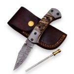 Damascus Pattern Pocket Knife shown partially open with a curved black-and-silver blade, tan wood-grain-look handle, patterned metal fittings and separate gold-ended rod.