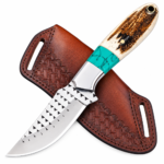 Turquoise accent fixed blade knife with triangular blade details and a cream-and-brown handle, resting diagonally over a brown basketweave-style sheath.