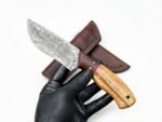 Two-Tone Wood Handle Damascus Hunting Knife with patterned drop-point blade, golden-brown and dark wood-grain handle, beside a brown stitched sheath.