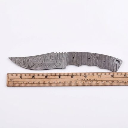 Damascus Drop Point Knife Blank with layered steel-style patterns, curved blade, full tang handle, pre-drilled attachment holes and measurement ruler on white background.