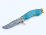 Turquoise Handle Damascus Pattern Knife with curved silver-gray blade, decorative gold-tone guard, blue patterned grip and brown multi-strap sheath.