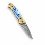 Blue Marble Damascus Folding Knife shown open with silver-gray patterned blade, blue-and-white marbled handle and gold-tone grid-patterned bolsters