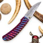 Red Blue Damascus Folding Knife shown open with a pointed silver-gray patterned blade, gold-colored thumb stud and ribbed red-and-blue handle.