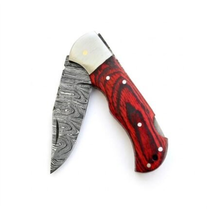 Red grain handle folding knife shown open beside a ruler, with a gray patterned blade, silver-tone bolster, and red-and-black contoured grip.