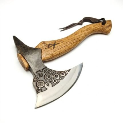 Spiked Viking style axe with a bright crescent blade, circular decoration on a dark head, curved brown grain-look handle, and dark loop.