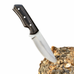 Black handle fixed blade hunting knife positioned on natural tree bark with pointed satin-finished blade