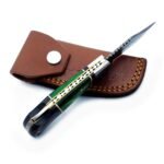 Green and black camping knife handle with decorative gold-tone pins