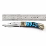 Turquoise Handle Folding Pocket Knife with silver-toned pointed blade, blue and black mosaic-style grip, and ornate gold-colored floral bolsters