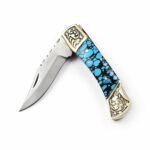 Turquoise Handle Folding Pocket Knife with silver-toned pointed blade, blue and black mosaic-style grip, and ornate gold-colored floral bolsters