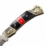 Ornate Black and Red Folding Knife shown open with a satin silver blade, black handle sections, red marbled inlay and floral engraved gold-tone bolsters
