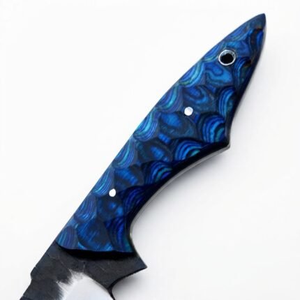 Blue Scalloped Handle Fixed Blade Knife with dark-and-silver curved blade, tapered patterned grip and reddish-brown embossed sheath displayed against a small log.