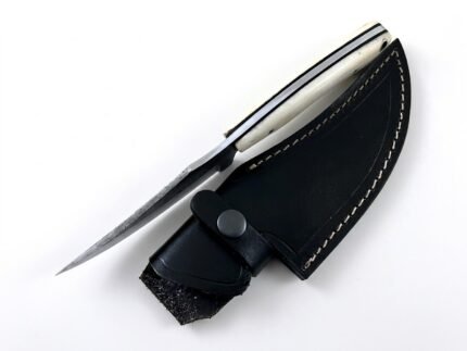 Ivory Handle Curved Skinner Knife with silver-gray Damascus-style patterned blade, cream-colored contoured handle and black stitched leather-style sheath.