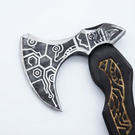 Viking Axe with Engraved Head featuring a curved black handle with brown-gold patterns, silver-gray geometric axe head and brown leather-style blade cover.