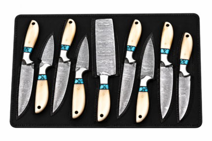 7 Piece Damascus Knife Set showing seven patterned kitchen knives with ivory-look handles, turquoise-blue decorative accents, and silver-colored bolsters in a black storage case.