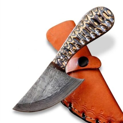 Patterned Handle Damascus Skinning Knife with broad curved gray blade, cream and black decorative handle and orange-brown stitched sheath