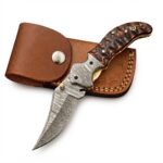 Wavy Handle Damascus Folding Knife with curved patterned blade, black and copper-brown sculpted handle, ornate silver pivot and brown snap-closure pouch.