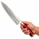 Damascus Steel Chef Knife with long wave-patterned blade, glossy ruby-red handle, pink decorative spacer, and gold-colored metal fittings.