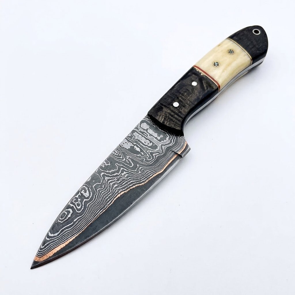 c8f94e8e-778c-41ec-a074-dd891c4cdd90 Damascus Pattern Fixed Blade Knife with pointed silver-gray patterned blade, black and ivory-style handle, decorative pins and metal-lined lanyard hole.
