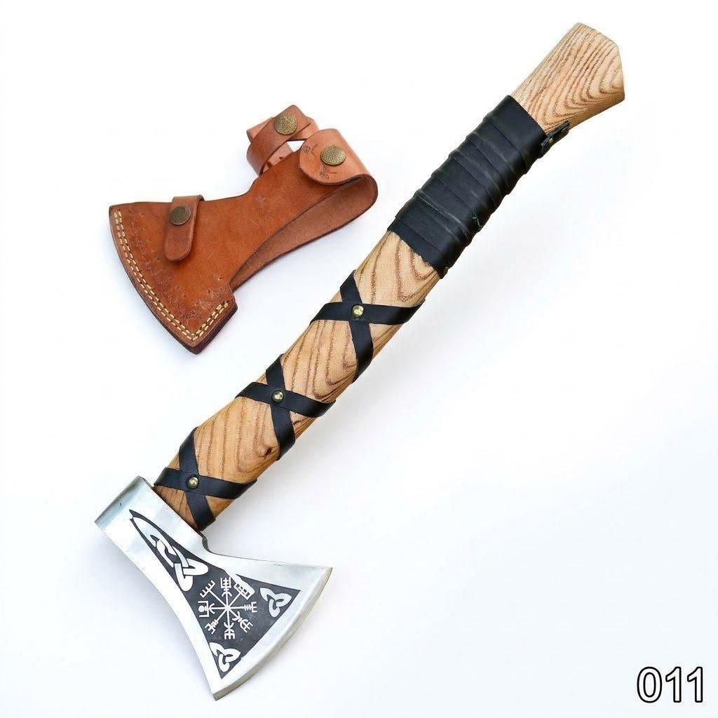 d213980e-00af-49df-bd4f-e18252d48a79 Engraved Viking Axe with silver Norse-patterned head, long wooden handle with black wraps, and brown protective blade cover