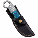 Turquoise Ring Handle Damascus Knife with curved silver-gray patterned blade, scalloped spine, turquoise and gray marbled grip, pictured beside a black stitched sheath.
