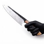 Wood Handle Fixed Blade Hunting Knife with silver drop-point blade, dark scalloped spine, light brown three-pin handle and tan stitched sheath.