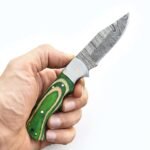 Damascus Steel Folding Pocket Knife with patterned curved blade, green wood-style handle, silver-toned bolster and decorative metal pins on white background.