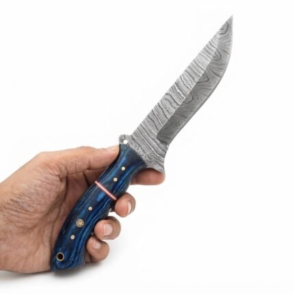 Blue grain handle knife with a broad gray patterned blade, copper-tone divider, four silver-tone pins, a mosaic-style pin, and a rear lanyard opening.