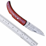 Curved Wood Handle Damascus Hunting Knife with patterned silver-gray pointed blade, upward-curving reddish-brown handle, decorative inlay and ruler beside it.