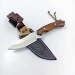 Fixed Blade Hunting Knife with polished silver blade, brown wooden handle, green cord lanyard, and decorative brown leather-style sheath