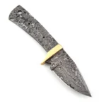 Raindrop-pattern knife blank with guard in gold tone, exposed full tang, two small holes, and a larger rear opening beside an inch-and-centimeter ruler