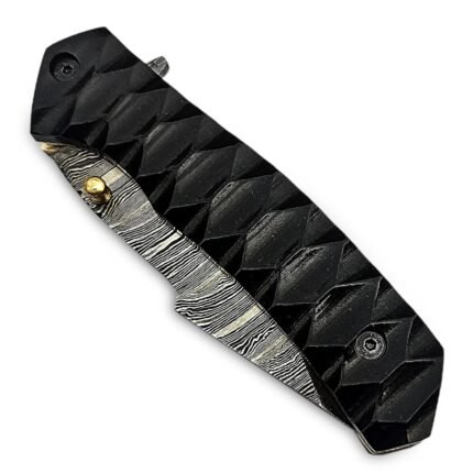 Damascus Pattern Folding Knife with pointed silver-and-black blade, raised geometric black handle, two dark hexagonal fasteners and gold-tone thumb stud