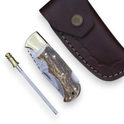 Damascus Folding Knife with curved silver-gray patterned blade, cream-and-brown stag-style handle, polished gold-tone bolster, metal pins and lanyard opening.