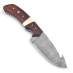 Damascus gut hook hunting knife with patterned curved blade, brown and cream handle, mosaic pin and dark brown stitched sheath with star-shaped metal decorations.