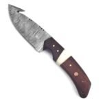 Damascus gut hook hunting knife with patterned curved blade, brown and cream handle, mosaic pin and dark brown stitched sheath with star-shaped metal decorations.