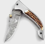Damascus Pattern Folding Pocket Knife with silver-gray patterned blade, curved brown-and-cream stag-style handle, metal thumb studs, detailed spine view and black stitched sheath.