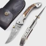 Damascus Pattern Folding Pocket Knife with silver-gray patterned blade, curved brown-and-cream stag-style handle, metal thumb studs, detailed spine view and black stitched sheath.