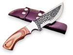 Hammered Pattern Hunting Knife with dark circular blade detailing, silver bevel, light brown wood-grain-look handle and burgundy double-strap sheath.