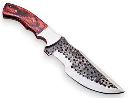 Hammered finish hunting knife with broad curved silver blade, dark circular dimples and red-black wood-grain handle