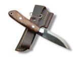 Rustic fixed blade knife with a dark textured blade, brown grain-pattern handle, two silver-tone pins, and bright bolster over a brown stitched sheath.