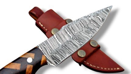 Geometric handle fixed blade knife with a silver-gray patterned blade and brown-and-tan grip, resting across a brown sheath with star fittings.